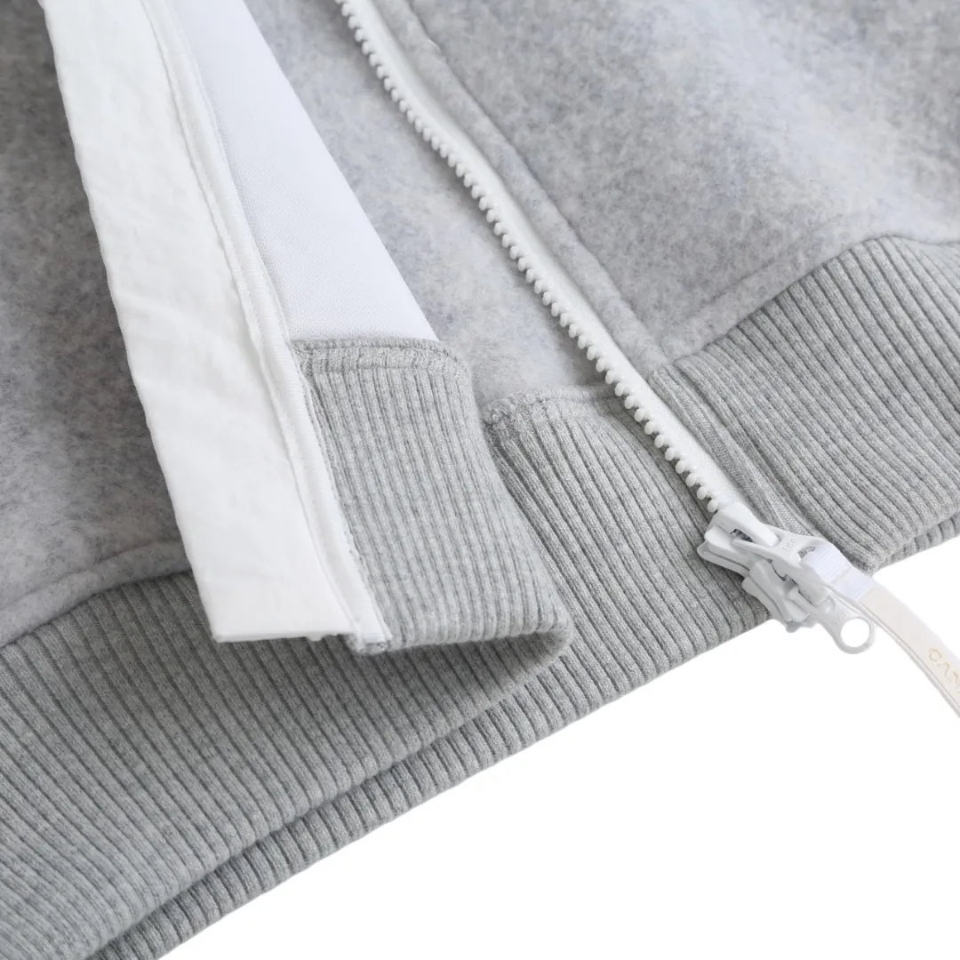 P780 Canada Goose Wool Fleece Hooded Jacket (Light Gray) The fabric is made of wool fleece fabric, which is mainly made of wool and mixed with a very small amount of spandex and polyester fiber. Wool is a core natural ingredient that provides unparalleled temperature regulation, antibacterial and anti-odor properties and a skin-friendly feel. The feeding of a small amount of spandex gives the fabric a certain degree of four-way elasticity, making it non-restrictive during daily activities. As the basis of fleece's structure, polyester fiber enhances the fabric's durability, wrinkle resistance and quick-drying properties. It contributes to the loft of the fleece and provides functions such as trapping air. The sleeves and hem are closed with 2×2 ribbing. Its strong elasticity can closely fit wrists and waists of different thicknesses, forming an effective 'seal' to prevent cold wind from blowing back. It can still maintain its original shape after repeated stretching and use, and is not easy to loose and deform. And the ribbed cuffs can convey a sense of design and enhance the visual beauty. The combination of hood design and elastic buckle improves warmth and windproof performance when worn. Size:S-M-L-XL